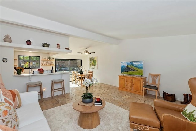 living room featuring beam ceiling and ceiling fan