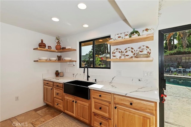 bar with light stone countertops and sink