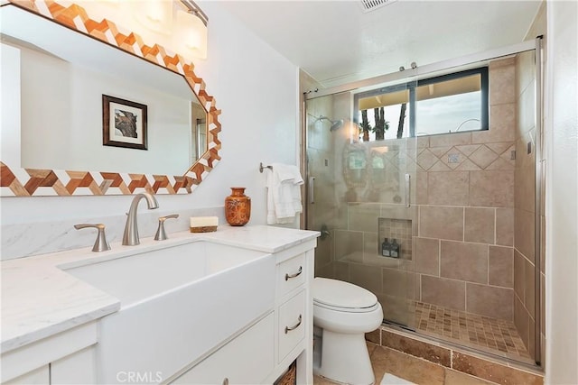 bathroom with a shower with door, vanity, and toilet