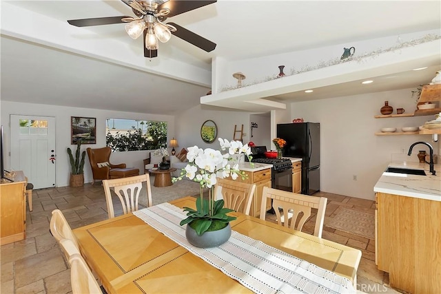 dining space featuring ceiling fan and sink