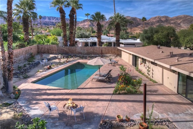 view of swimming pool with a mountain view, an outdoor fire pit, and a patio area