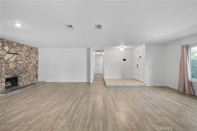 unfurnished living room featuring a fireplace and light hardwood / wood-style flooring