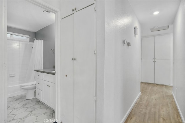 full bathroom with hardwood / wood-style floors, vanity, toilet, and shower / bath combo