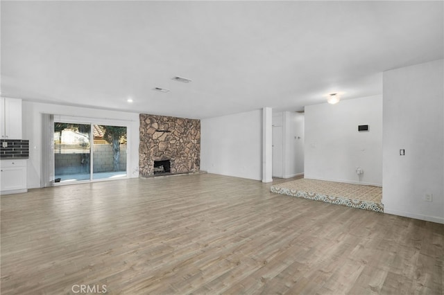 unfurnished living room with a fireplace and light hardwood / wood-style floors