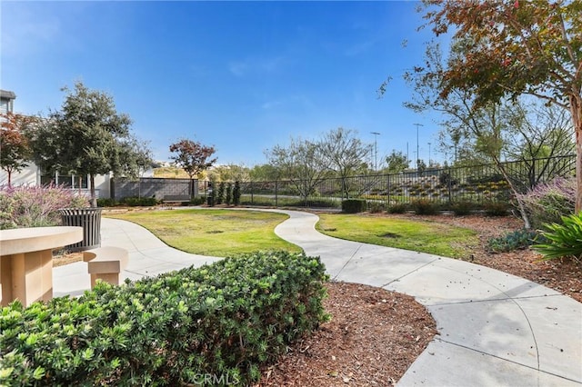 view of community featuring fence and a lawn