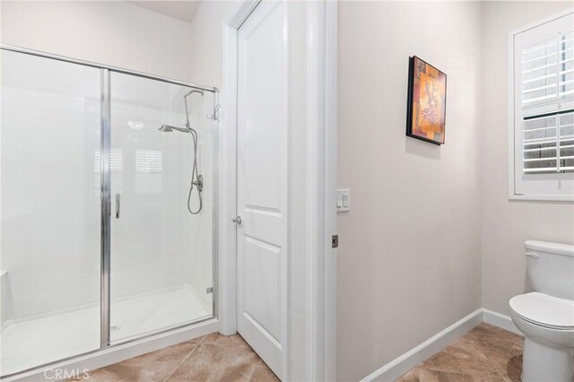 bathroom with tile patterned floors, toilet, and walk in shower