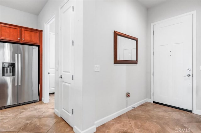 foyer featuring light tile patterned flooring and baseboards