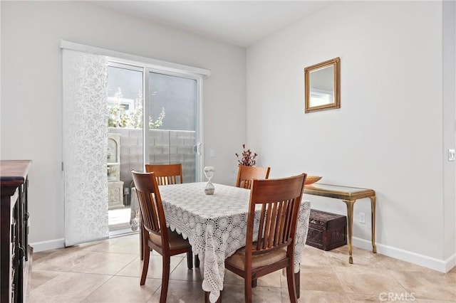 dining space featuring baseboards and light tile patterned floors