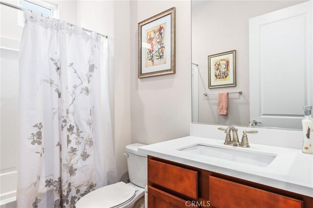 bathroom with a shower with curtain, vanity, and toilet