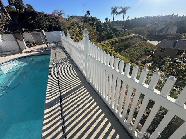 view of swimming pool with a fenced in pool and fence