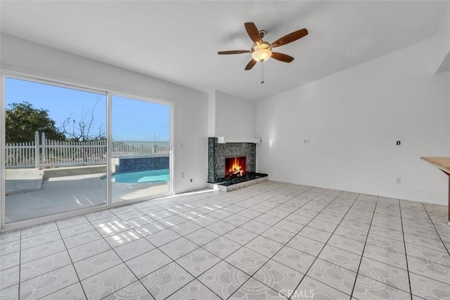 unfurnished living room featuring a fireplace, light tile patterned floors, and ceiling fan