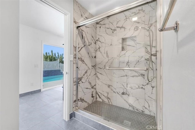 bathroom featuring a marble finish shower and tile patterned flooring