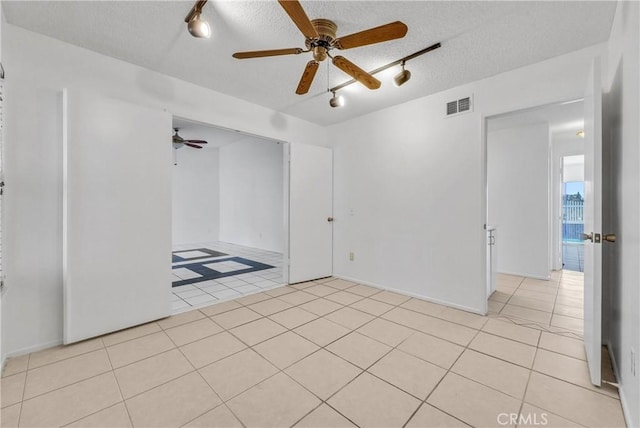 tiled spare room featuring ceiling fan and a textured ceiling