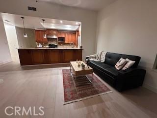 living area featuring baseboards, visible vents, and light wood-style floors