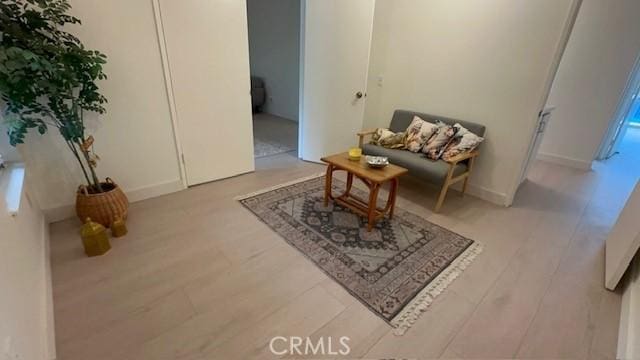 living area featuring baseboards and wood finished floors