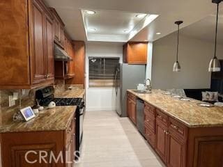kitchen with a peninsula, a sink, brown cabinetry, and gas stove
