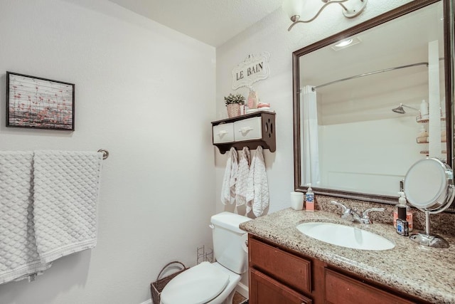 bathroom with vanity, walk in shower, and toilet