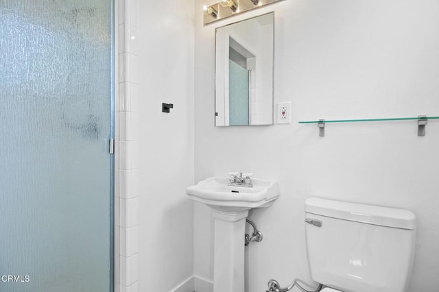 bathroom with toilet and a shower with shower door