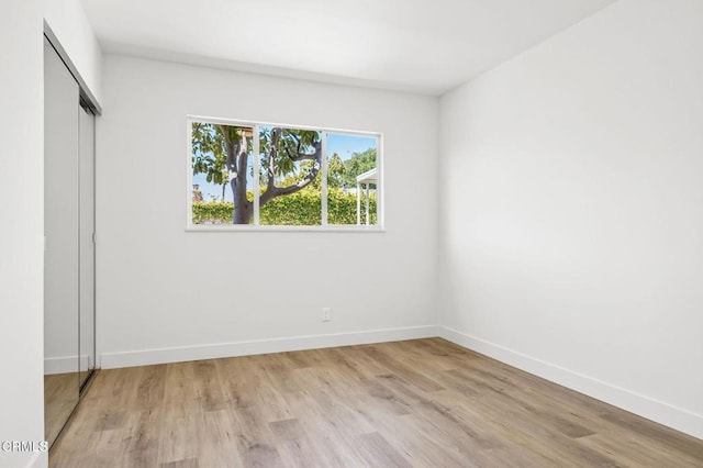 unfurnished bedroom with light hardwood / wood-style floors and a closet