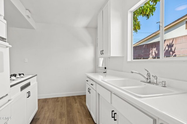 kitchen featuring sink, white cabinetry, and dark wood-type flooring