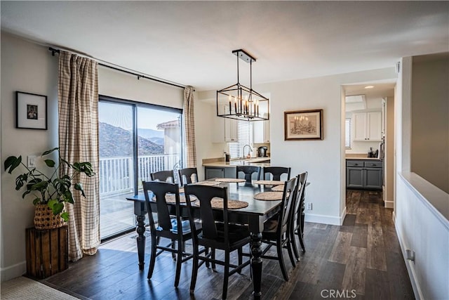 dining room with a mountain view, dark wood-type flooring, and a chandelier