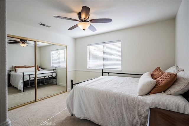 carpeted bedroom featuring ceiling fan and a closet