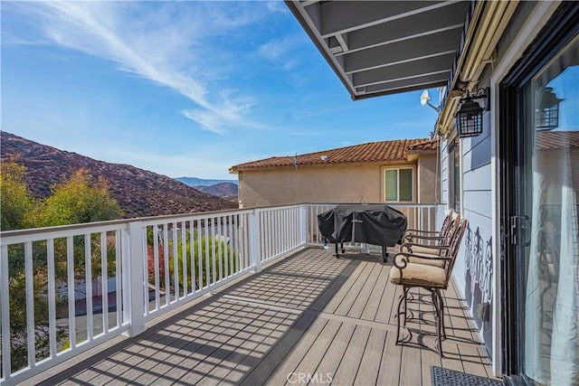 wooden terrace featuring a mountain view and a grill