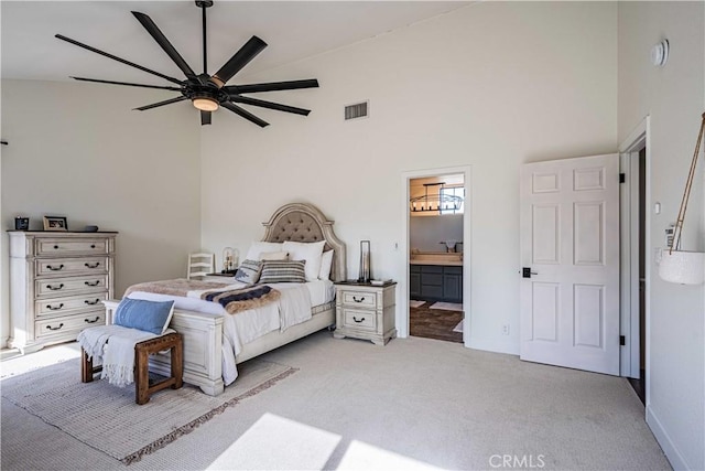 carpeted bedroom with connected bathroom, high vaulted ceiling, and ceiling fan