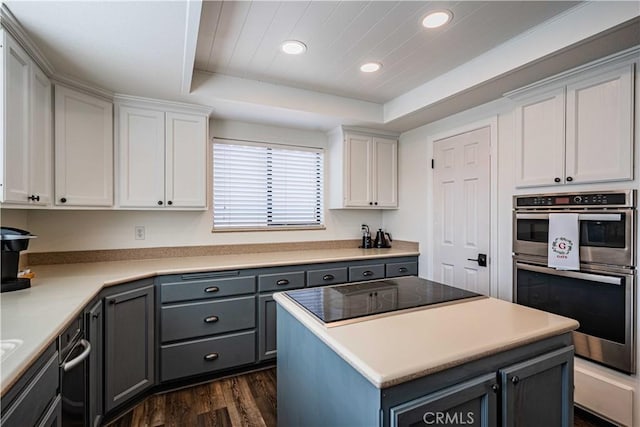 kitchen with a raised ceiling, dark hardwood / wood-style flooring, white cabinets, and black electric stovetop