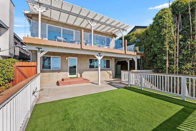 back of property featuring a yard, a pergola, a balcony, and a patio area