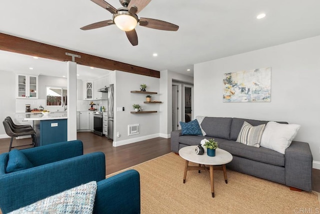 living room featuring beamed ceiling, hardwood / wood-style flooring, and ceiling fan