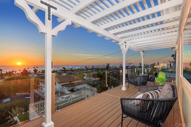 deck at dusk with an outdoor living space and a pergola