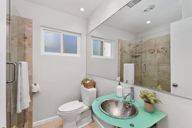 bathroom featuring toilet, sink, tile patterned flooring, and walk in shower