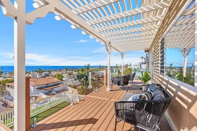 wooden deck with a water view and a pergola