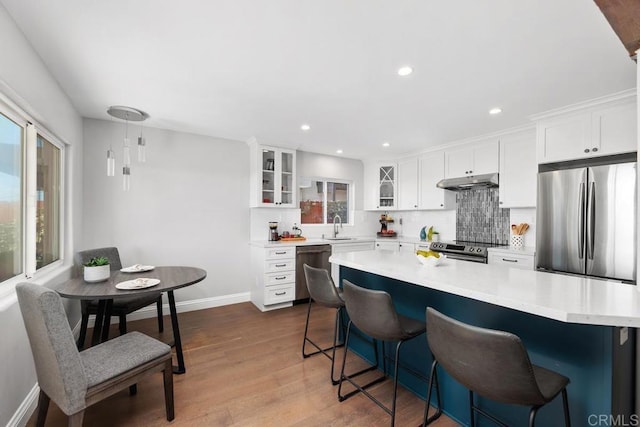 kitchen featuring appliances with stainless steel finishes, sink, light hardwood / wood-style floors, and white cabinetry