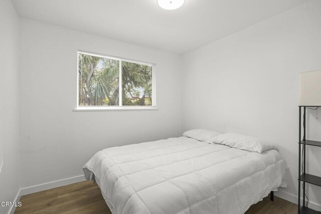 bedroom with dark hardwood / wood-style flooring