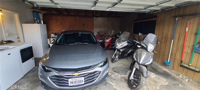 garage featuring washer and dryer and wood walls