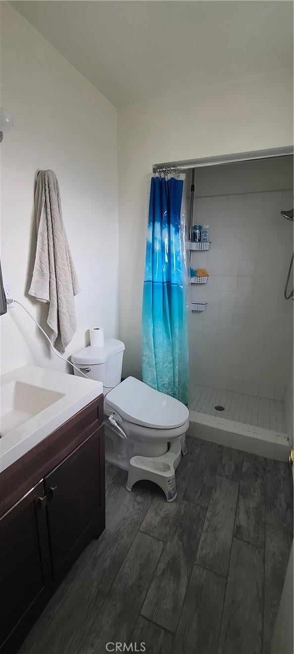 bathroom with curtained shower, toilet, and vanity