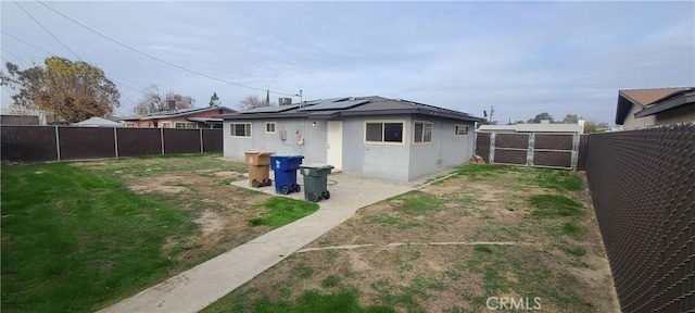 rear view of property featuring solar panels