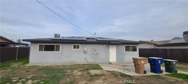 rear view of property with solar panels