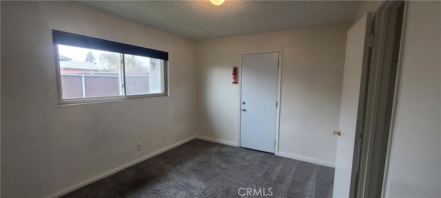 carpeted spare room featuring a textured ceiling