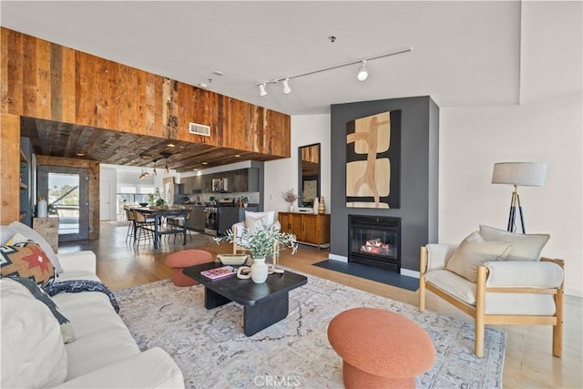 living room with light hardwood / wood-style floors and wood walls