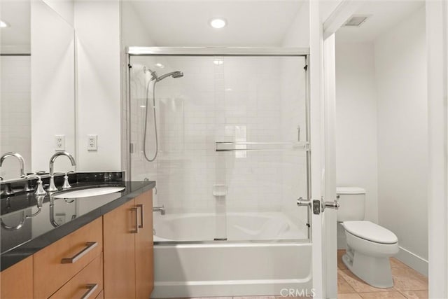 full bathroom with combined bath / shower with glass door, tile patterned floors, vanity, and toilet