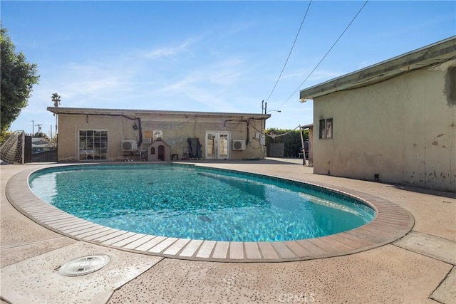 view of swimming pool featuring french doors and a patio