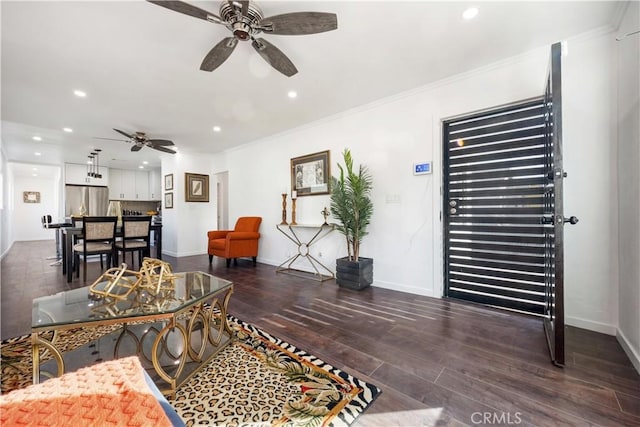 living room featuring dark wood-type flooring, ornamental molding, and ceiling fan