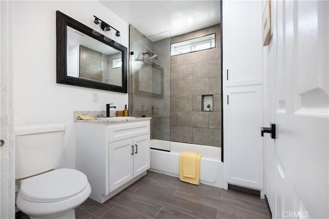 full bathroom featuring toilet, tiled shower / bath combo, and vanity