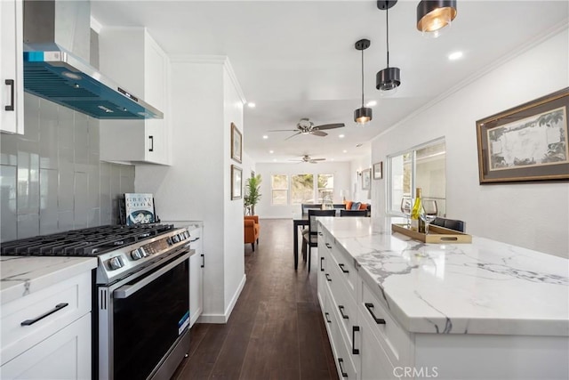 kitchen featuring dark wood-type flooring, crown molding, gas range, wall chimney exhaust hood, and backsplash