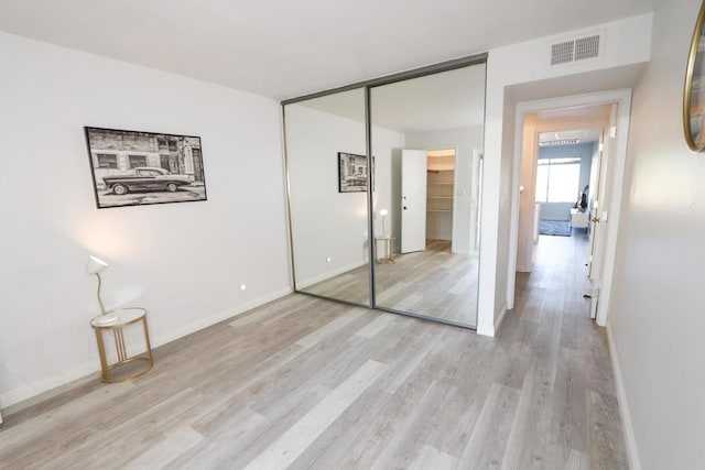 unfurnished bedroom featuring light wood-type flooring and a closet