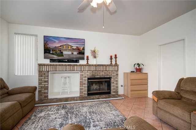 tiled living room with ceiling fan and a brick fireplace