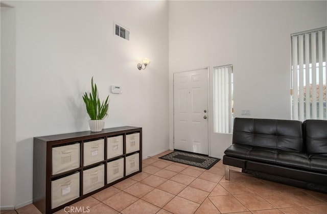 tiled foyer entrance featuring a towering ceiling